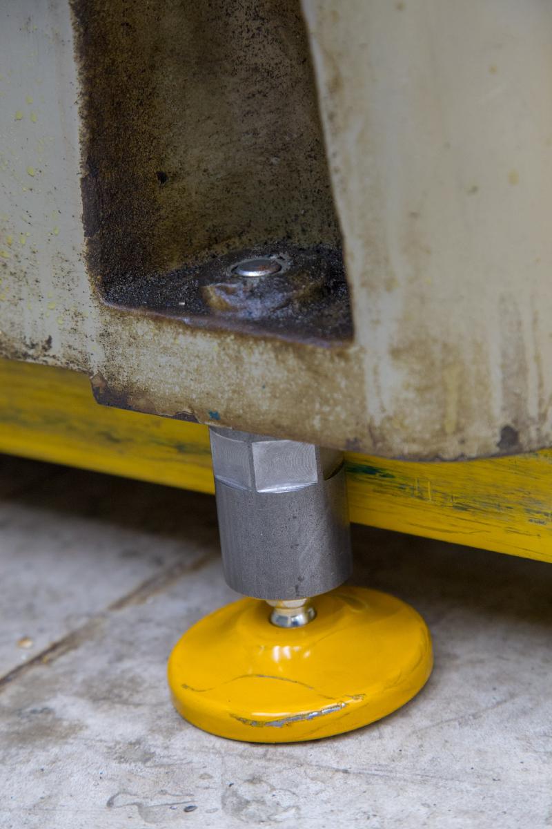 Machine foot with yellow levelling pad installed