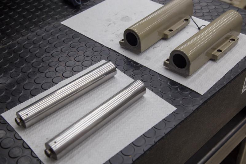 Hydraulic cylinder pistons and bores laid out on a bench